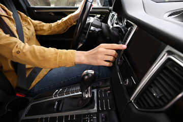 Woman using navigation system while driving her car, closeup