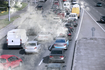 Environmental pollution. Air contaminated with fumes in city. Cars surrounded by exhaust on road