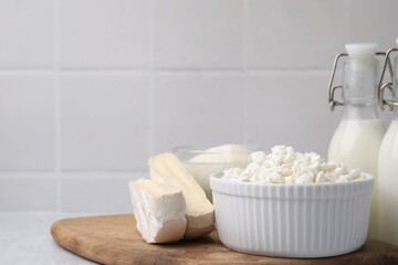 Different fresh dairy products on light table. Space for text