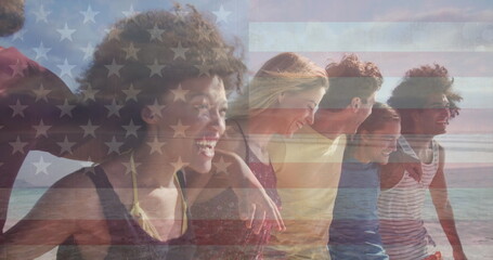 Image of flag of united states of america over happy diverse friends on beach