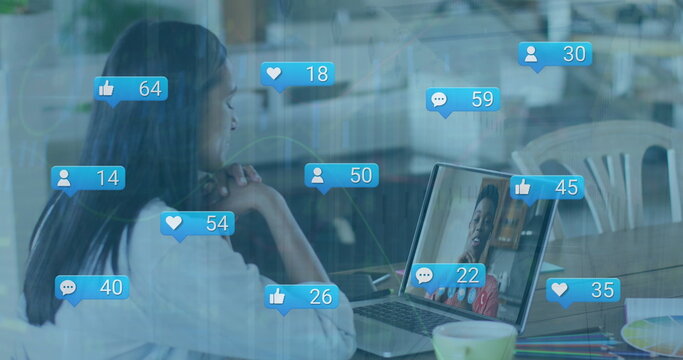 Image of digital interface and falling icons over biracial women using laptop