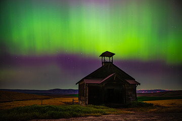 Abandoned Schoolhouse under the light of the Aurora Borealis. 