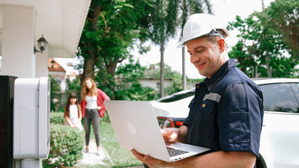 Qualified technician working on home EV charging station installation, making troubleshooting and...