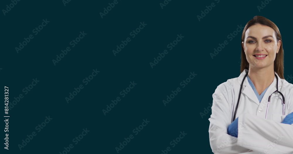 Poster Image of smiling female caucasian doctor standing arms crossed against black background