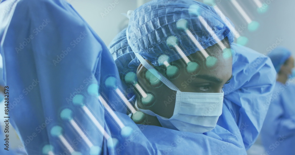 Poster Image of dna strand over diverse doctors with face masks during surgery