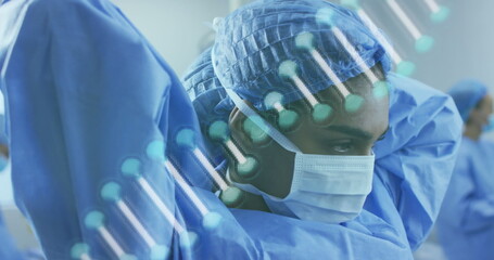 Image of dna strand over diverse doctors with face masks during surgery