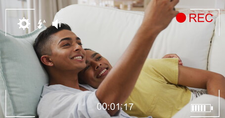 Image of digital interface over happy biracial male gay couple