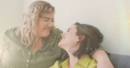 Image of light over happy caucasian female gay couple