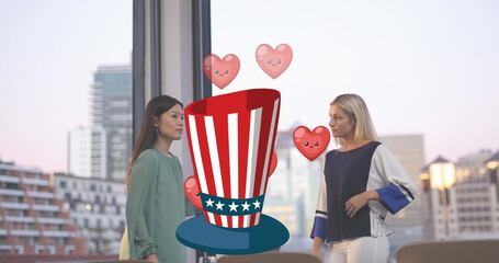 Image of hat in usa flag with hearts over diverse woman talking