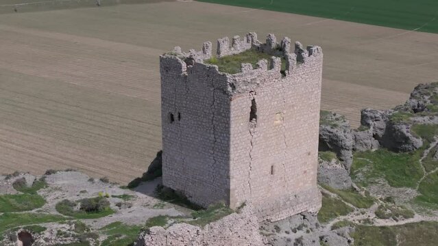 magnificent orbital flight with a drone over the 9th century Oreja castle creating a visual effect by filming in 70mm with a background of crop fields and a magnificent location of the fortress