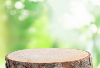 Wood tabletop round podium in outdoors background.