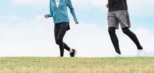 健康のため公園でウォーキング・散歩・有酸素運動するスポーツウェアを着た男女

