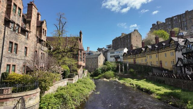 Water of Leith flowing through former Dean Village on sunny day. Pan right