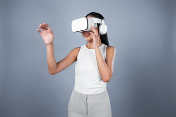 Smart female standing with gray background wearing VR headset connecting metaverse, futuristic...