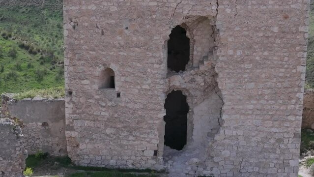 reverse flight with a close-up of a break in the tower where we see a window and stairs and discovering the magnificent location and its wild surroundings Oreja castle 9th century Ontigola Spain