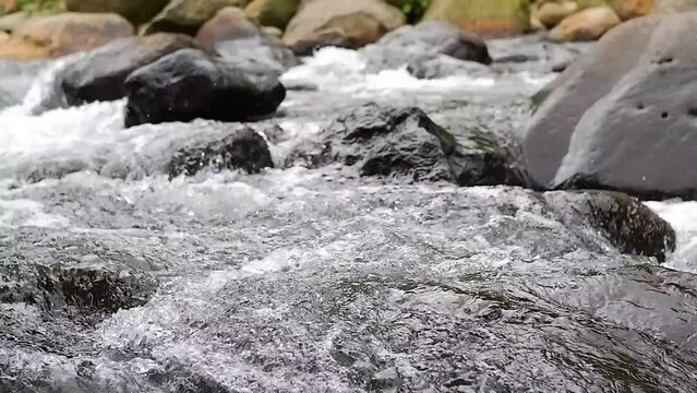 The flow of water flows fast in a clean river at the foot of Mount
