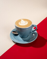 a cup of hot latte coffee on a red and white background