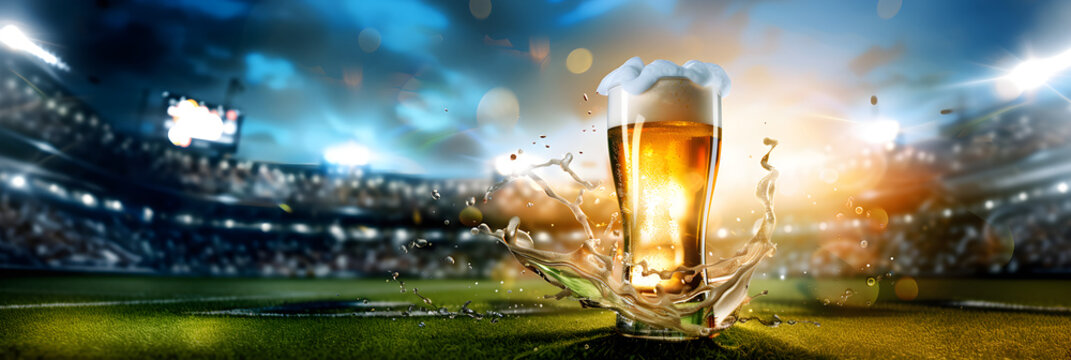Glass with lager foamy beer on grass at soccer  stadium. Game and drink, sports fan. Watch football or rugby match with friends. World championship cup. Super Bowl. Banner with copy space