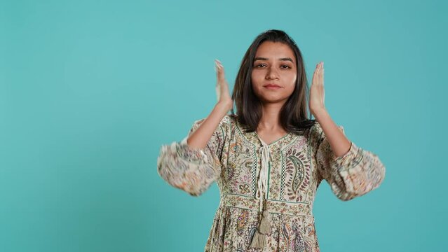 Woman covering eyes, ears and mouth, imitating three wise monkeys. Indian person doing don t see, don t hear and don t speak hand gesturing concept, studio background, camera A