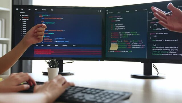 Slow motion back end software developer engineer for computer programming working together on debugging writing computing code, solving complex algorithms display on monitor in office. Burgeoning