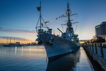 Fototapeta premium A majestic naval vessel docked at the harbor, open for public tours and showcasing the proud maritime history of the region, Generative AI