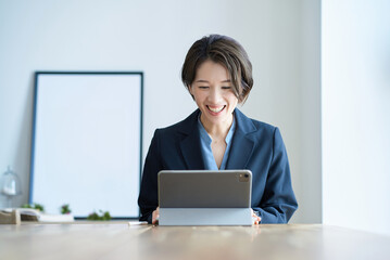 部屋で仕事をするスーツ姿の女性