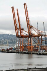 Obraz premium Harbor cranes towering over the waterfront, lifting heavy cargo from ships onto waiting trucks and trains, Generative AI