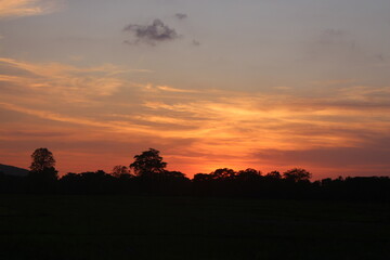 Sunset Sky Clouds in the evening with Red, Orange, Yellow and purple sunlight on Golden hour after sundown, Romantic sky in summer on Dusk Twilight