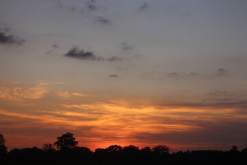 Sunset Sky Clouds in the evening with Red, Orange, Yellow and purple sunlight on Golden hour after sundown, Romantic sky in summer on Dusk Twilight