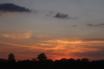 Sunset Sky Clouds in the evening with Red, Orange, Yellow and purple sunlight on Golden hour after sundown, Romantic sky in summer on Dusk Twilight