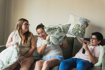 relaxed latin family playing a pillow fight