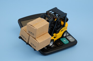 Forklift carrying carton boxes on black calculator on blue