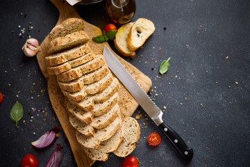 sliced bread on wooden cutting board on dark table