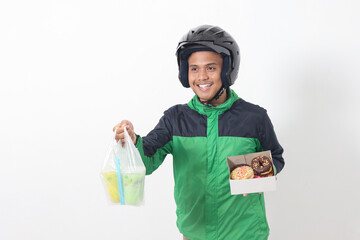 Portrait of Asian online taxi driver wearing green jacket and helmet holding a box of donuts and...