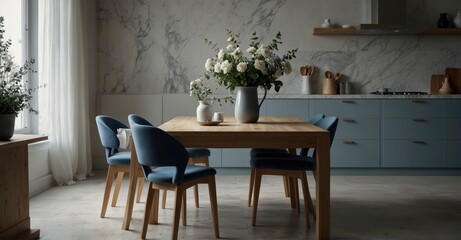 Clean marble dining table in a Scandinavian kitchen, featuring blue drawers on wooden furniture. Elegant tableware and vases filled with flowers complete the contemporary look