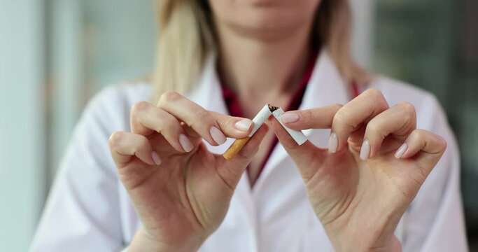 Doctor breaks cigarette in half and demonstrates dangers of smoking