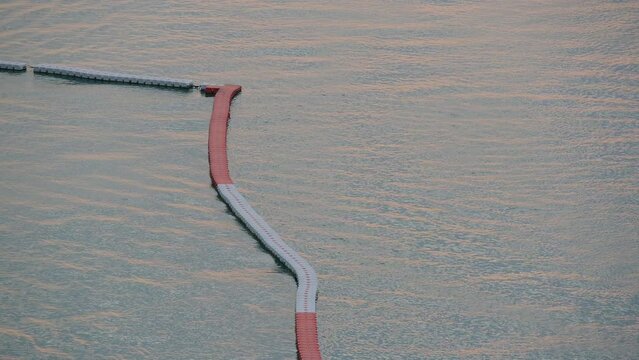 floating buoy barrier on sea, water wave in the evening