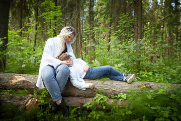 Obraz premium Funny mother with dreadlocks and fat boy happy walking in the woods on a sunny summer day