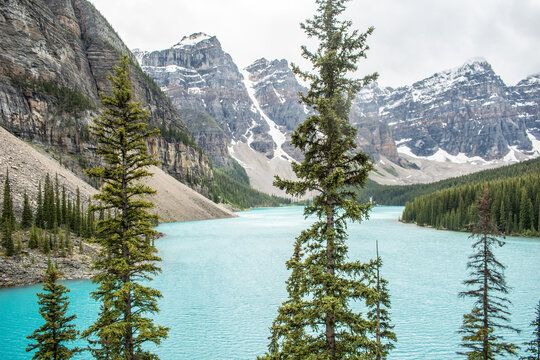 This breathtaking image captures the serene beauty of a majestic mountain rising proudly above a Lake Louise. The snow-capped peak towers in national park
