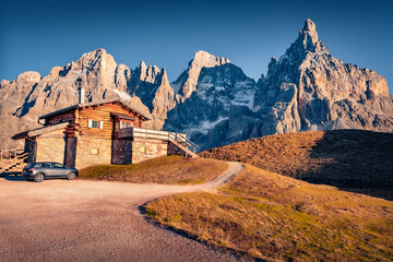 Mountain shelter with a car. Fantastic evening scene of Dolomite Alps. Stunning autumn view of...