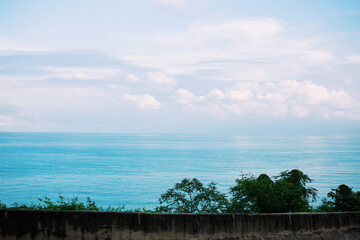 The road barrier has a background of the sea and sky.