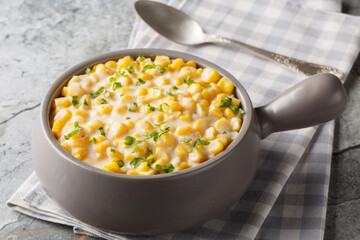 Creamy corn with cream, milk and grated parmesan closeup on the bowl on the table. Horizontal