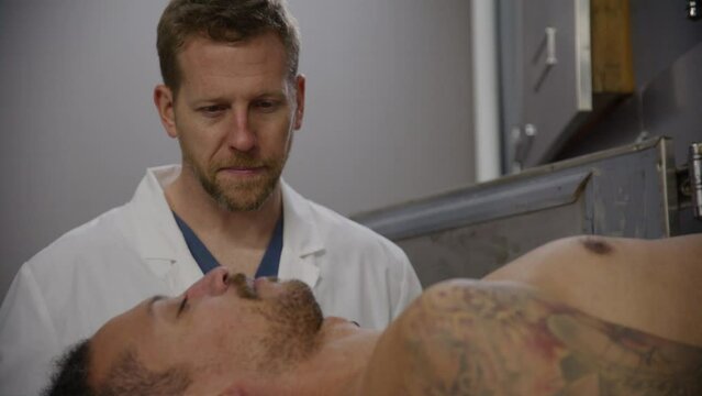 Young corpse and medical examiner in hospital morgue