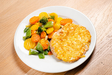 cutlet with roasted vegetables on white plate