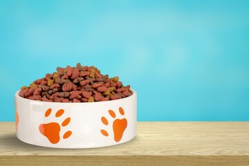 Dry cat dog food in bowl on background