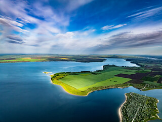 aerial view over peninsula covered with green grass at costesti reservoir at duruitoarea village on the north of moldova during morning with lue sky