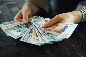 Hands holding russian rouble and us dollar bills. dollars and rubles. concept of currency exchange.