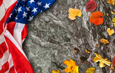 USA flag buried in yellow dry leaves. Autumn texture