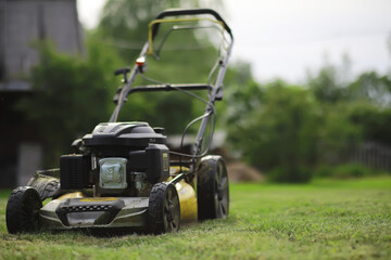 Lawn mover on green grass in modern garden. Machine for cutting lawns.