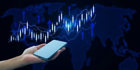 Close up of female hand holding cellphone with growing forex chart with arrow and map on dark...